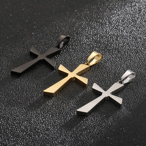Close-up of polished cross pendants in black, gold, and silver stainless steel