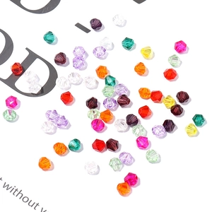 Macro shot of 4mm faceted bicone glass beads in various vibrant colors for DIY jewelry