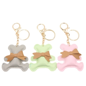 Cute cartoon PU leather bear keychains in grey, green, and pink with brown bows