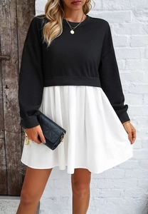Détail de robe bicolore avec haut sweat-shirt noir et jupe plissée blanche