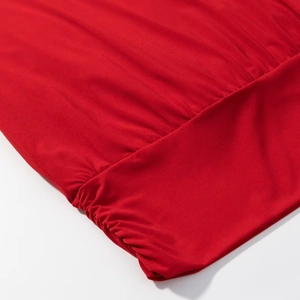 Vue détaillée du tissu rouge froncé avec coutures de qualité et texture soyeuse