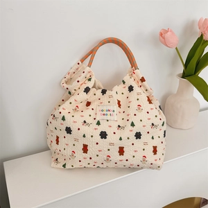 Dettaglio della borsa trapuntata con stampe natalizie e manici in corda colorati