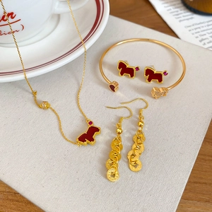Luxurious gold jewelry set with red horse charms and zircon accents on beige background