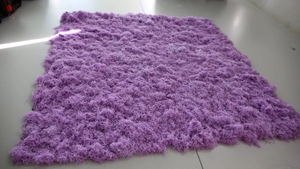 Detailed view of fluffy long-pile purple artificial moss rug on tile floor