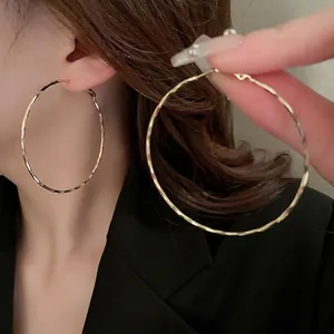 Sparkling gold hoop earrings with hammered metal texture for a minimalist fashion style