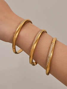 Gros plan détaillé de trois bracelets en acier inoxydable doré sertis de oxydes de zirconium