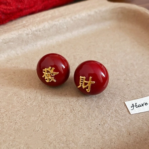 Détail macro de boucles d'oreilles dorées rouges avec caractères chinois de chance