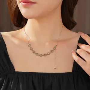 Elegant gold necklace with crystal-encrusted round discs and asymmetric drop pendant