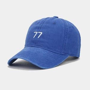 Gros plan sur la broderie 77 sur le tissu bleu roi délavé de la casquette vintage