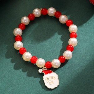Détail du bracelet de Noël avec pendentif Père Noël et perles festives rouges et blanches