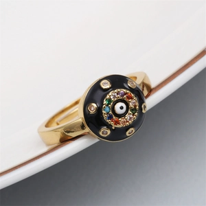 Detail of gold evil eye ring featuring colorful zircons and blue enamel charm