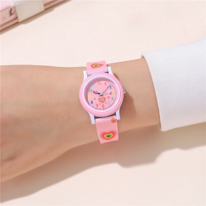 Detailed shot of pink kids watch featuring rainbow hearts and colorful numeric dial