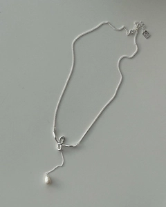 Detailed close-up of a sterling silver bow pendant with a water-drop natural freshwater pearl