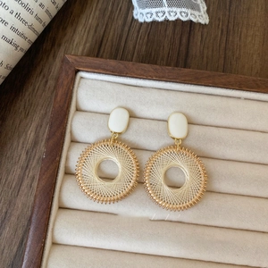 Bohemian gold woven hoop earrings with white square accent on beige velvet jewelry box