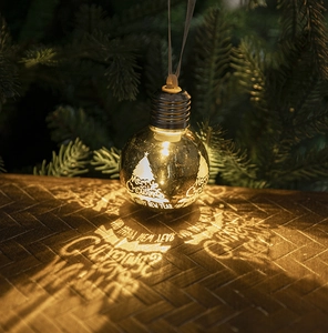 Detail of warm light Christmas bulb ornament projecting Merry Christmas message