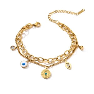 Double-layered gold evil eye bracelet with blue enamel charms and crystal pendants