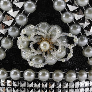 Detail of silver faux pearls and floral beadwork on a luxury black sequined party hat
