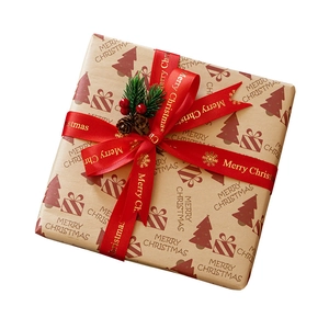 Christmas kraft paper gift box with red Merry Christmas ribbon and pine berry decoration