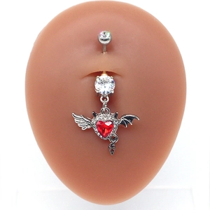 Macro detail of devil heart belly ring with red gemstone and silver bat wings