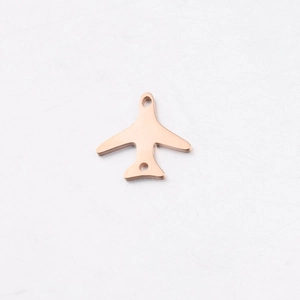 Macro shot of rose gold airplane pendant with dual holes and polished mirror surface