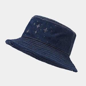 Detail of dark blue denim bucket hat with silver rhinestone star patterns and yellow stitching