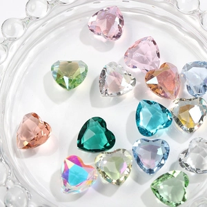 Detail view of 12mm heart-shaped glass crystals in various colors in a glass tray