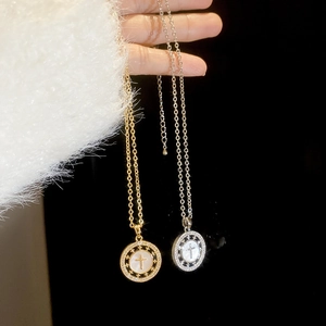 Détail de pendentifs croix en or 18 carats et argent avec cristaux et nacre blanche