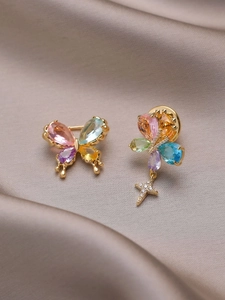 Detailed macro view of colorful butterfly jewelry with pear-cut gems and a star charm