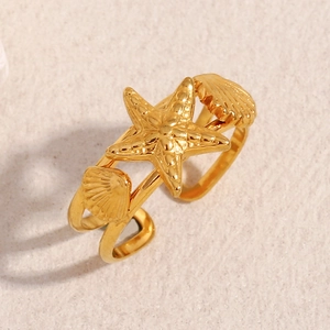 Detailed close-up of 18K gold starfish and seashell textures on an open ring