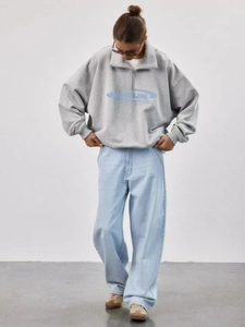 Gray half-zip pullover sweatshirt with SKUR logo paired with light blue jeans for a casual look