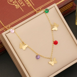Detailed macro view of gold butterfly pendants and colorful round gems on double layer chain