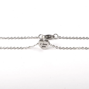 Detailed close-up of heart-shaped silver pendant engraved with I Love You text