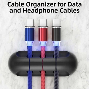 Detail of black silicone cable organizer with three slots on marble texture