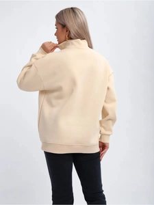 Back view of cream half-zip sweatshirt showing loose fit and soft fleece texture