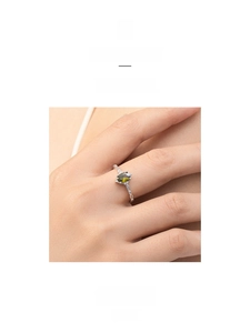 Detail of s925 silver ring with marquise olive green stone and side diamonds