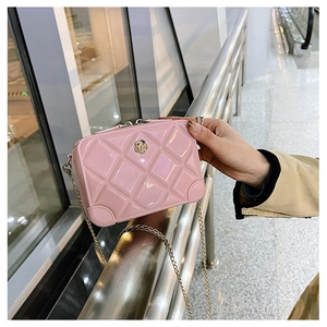 Detail of pink quilted PVC jelly bag with golden flower decor and chain strap