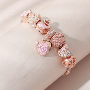 Bracelet perlé en or rose avec pendentif cygne et breloques cœur rose sur surface douce