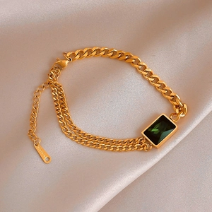 Détail du bracelet gourmette doré à deux rangs avec pierre précieuse verte sur soie