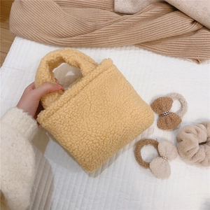 Gros plan d'un mini sac à main en laine d'agneau jaune avec texture granuleuse et douce