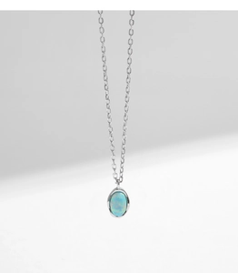 Macro shot of s925 silver wave necklace with oval opal pendant and fine link chain