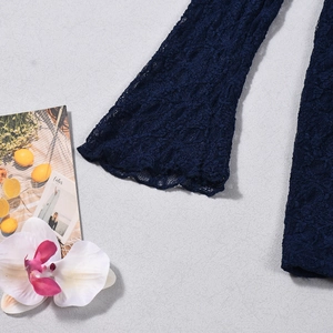 Detailed close-up of navy blue floral lace sleeve with intricate hollow-out embroidery