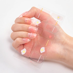 Detail of 3D laser gold nail stickers featuring poached egg and red heart patterns
