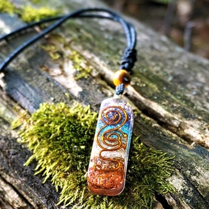 Handmade chakra energy stone resin pendant necklace with crystals on mossy wood background