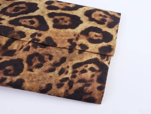 Primer plano de la textura jacquard con estampado de leopardo en pantalones de traje