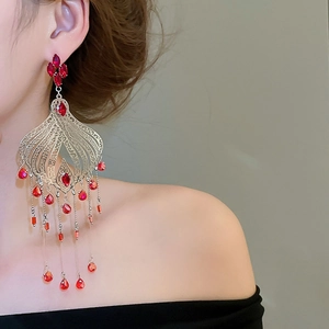 Macro detail of vintage palace-style crystal tassel earrings with ruby-red stones
