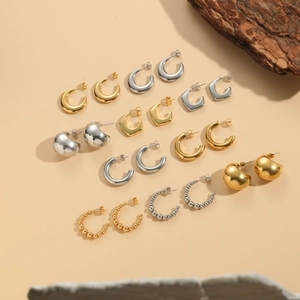 Detailed macro view of gold and silver geometric titanium steel hoop earrings set