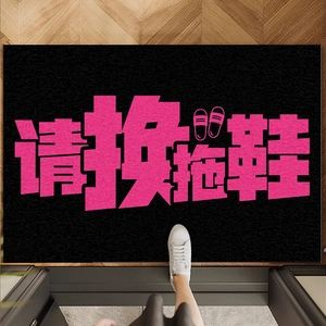 Black PVC entry mat with pink text and icons on wooden floor for indoor shoe change area