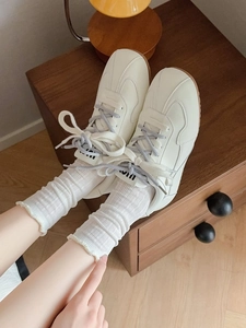 Close-up of retro off-white sneakers with mesh socks and brown gum rubber sole
