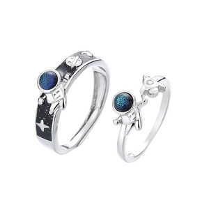 Astronaut themed silver couple rings with blue and black enamel details on white background