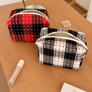 Vintage plaid wool toiletry bag set with red and black checkered patterns on wood